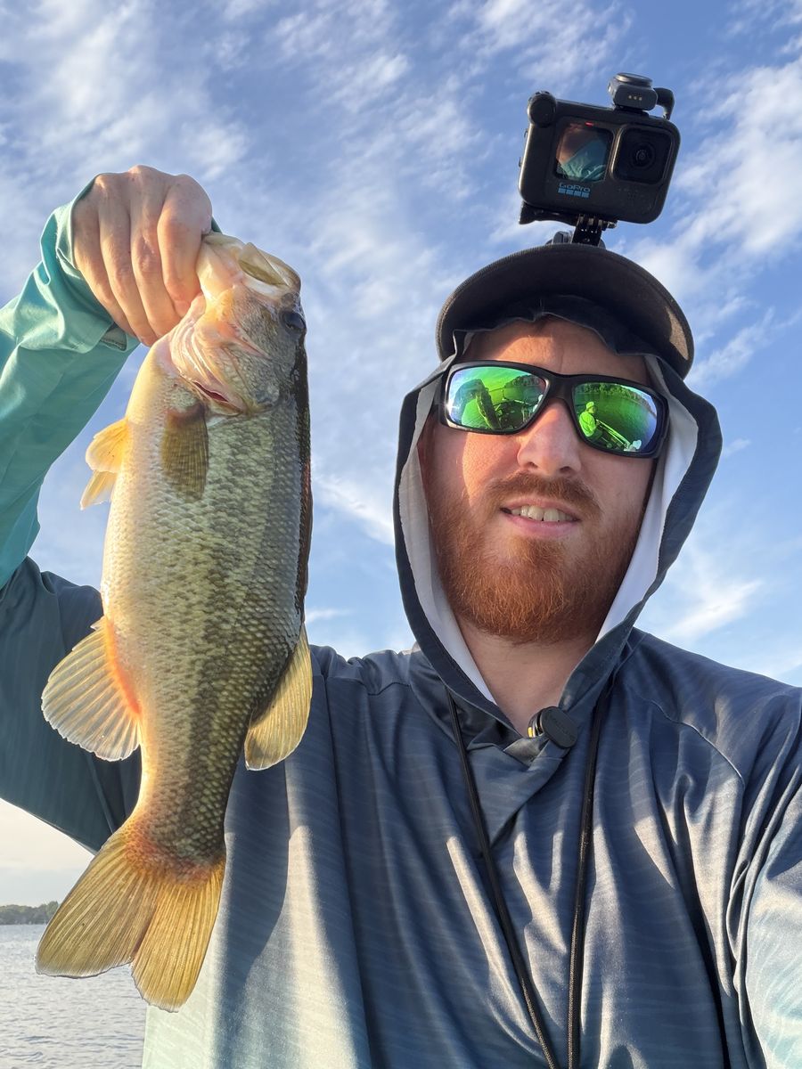 Scott with a largemouth bass and a GoPro on his cap