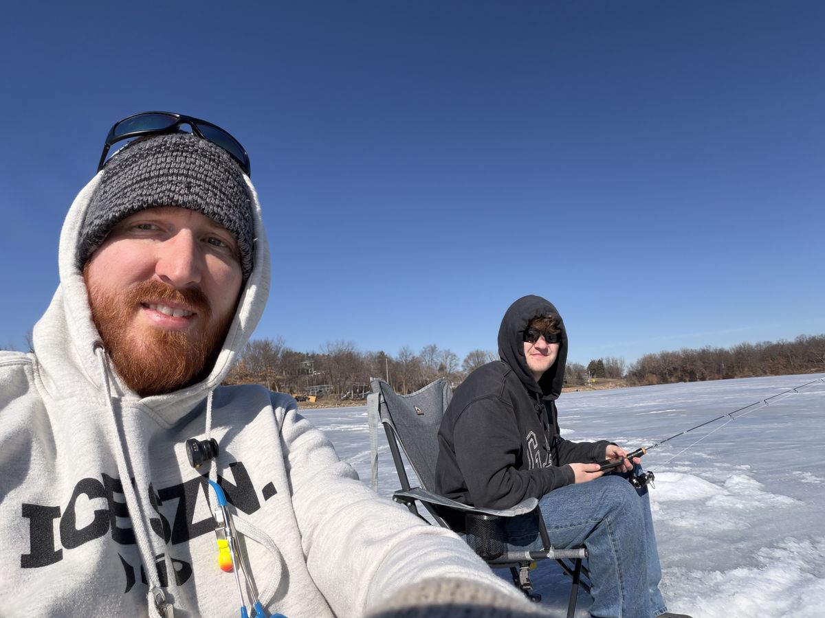 Scott and his son ice fishing on a sunny day